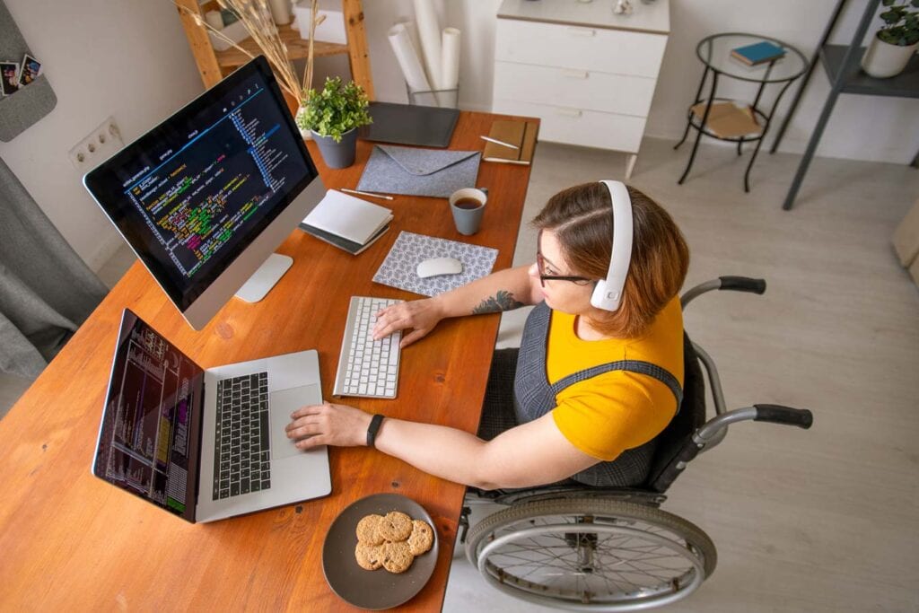 woman in wheelchair typing at a computer