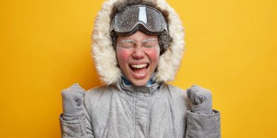 frost covered woman in parka screaming excitedly